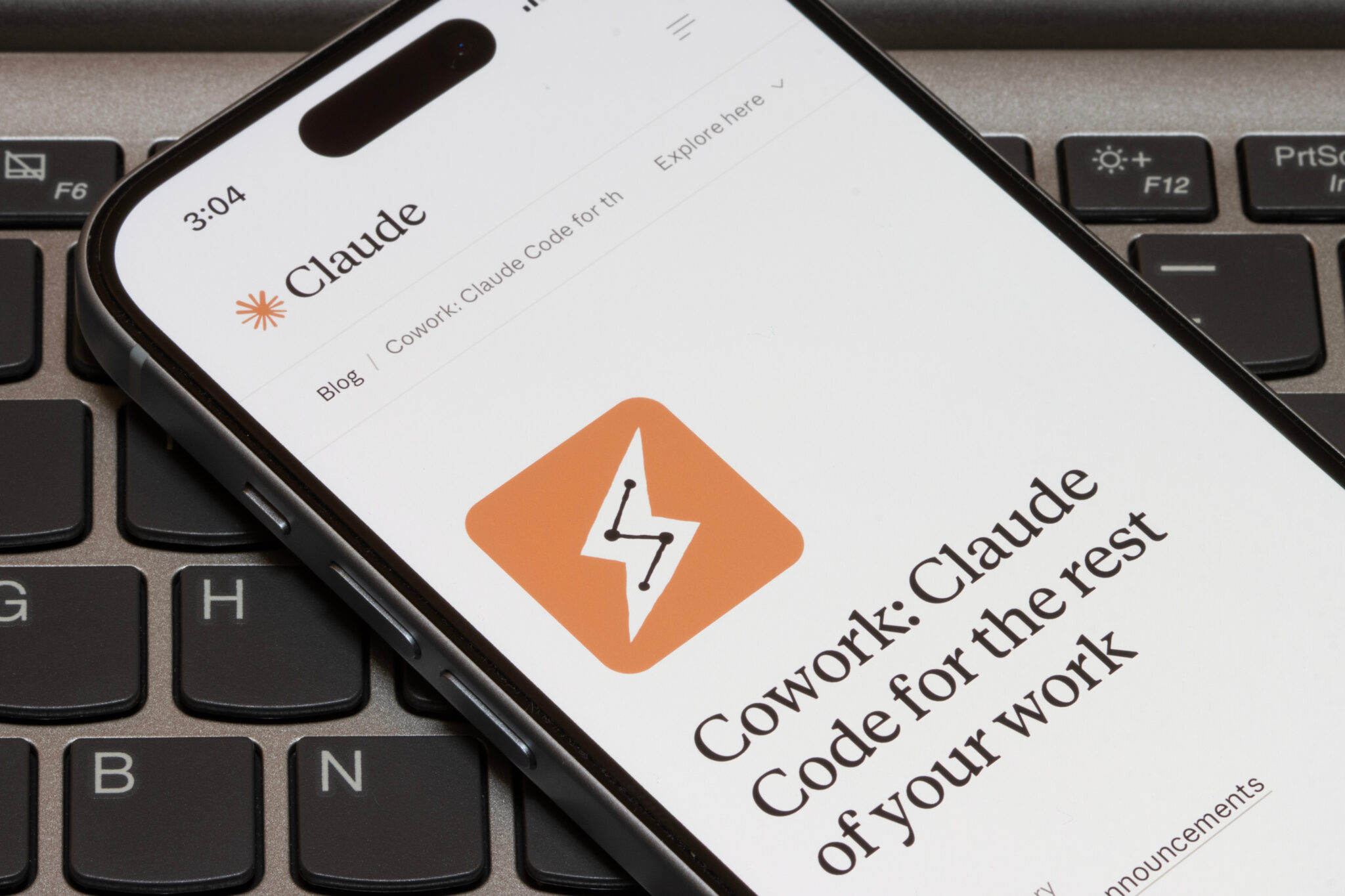 Smartphone-Anzeige des Claude-Blogs über effektive Code-Kollaboration im Coworking-Umfeld auf Laptop-Tastatur.