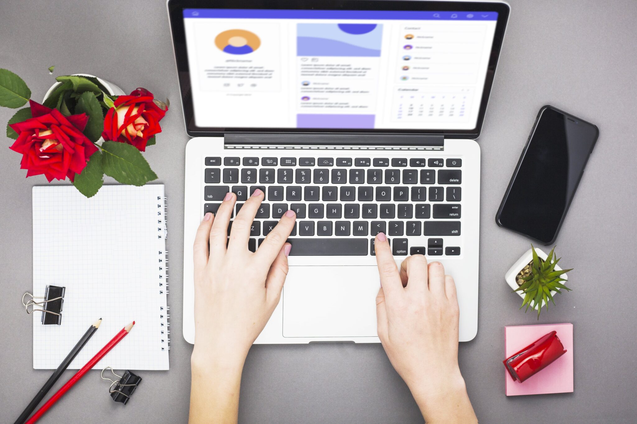 Laptop-Arbeit mit Blumen und Büroartikeln - Kreative Arbeitsplatzgestaltung für effizientes Homeoffice.