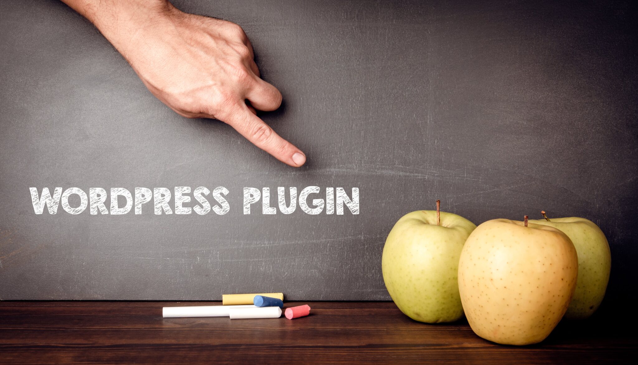Nahaufnahme von Hand zeigt auf Tafel mit WordPress Plugin für Beitrag über die besten WordPress-Plugins für Blogger.