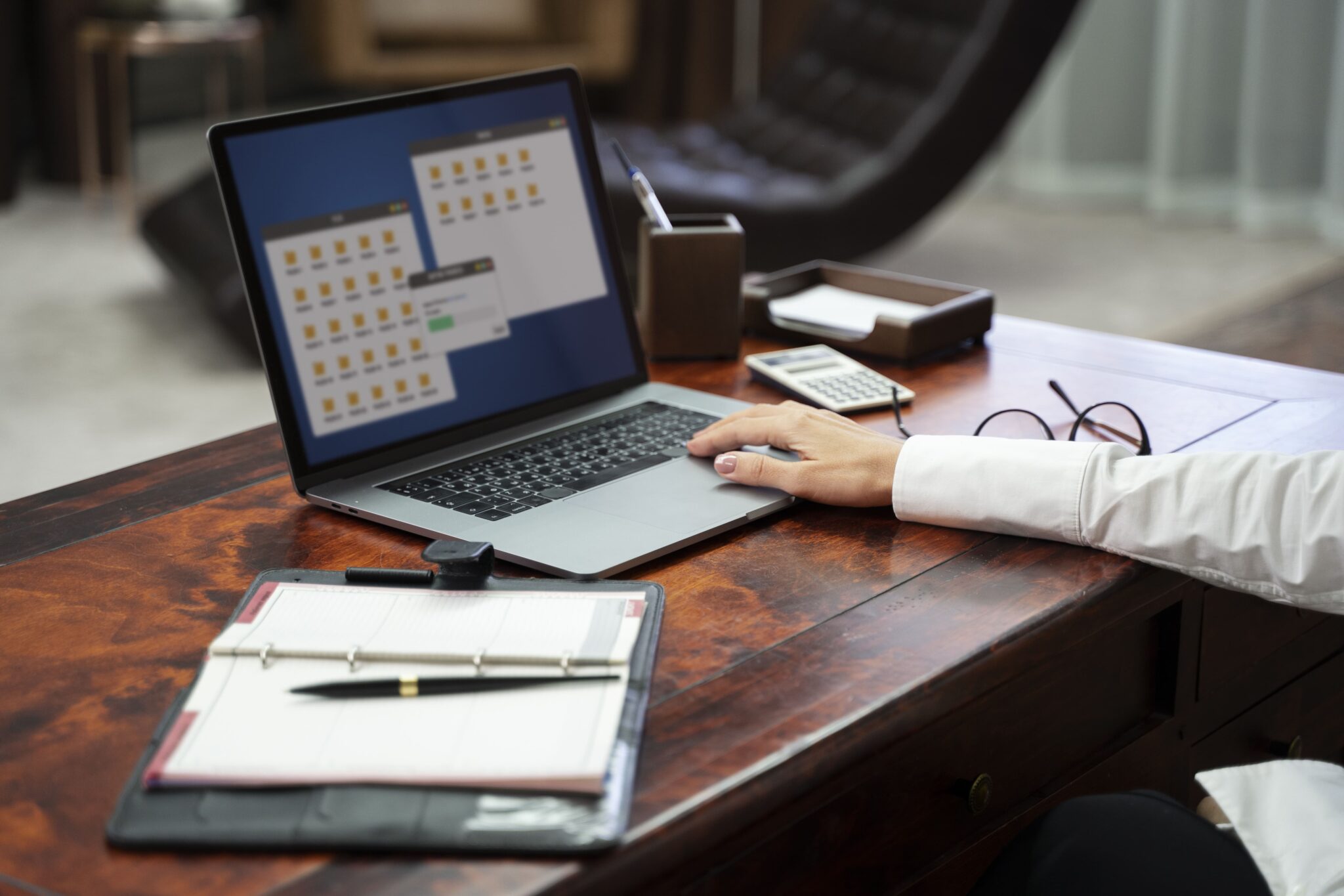Person nutzt Laptop im Büro für digitale Dateien, Thema: effizientes Arbeiten und Organisation am Arbeitsplatz.