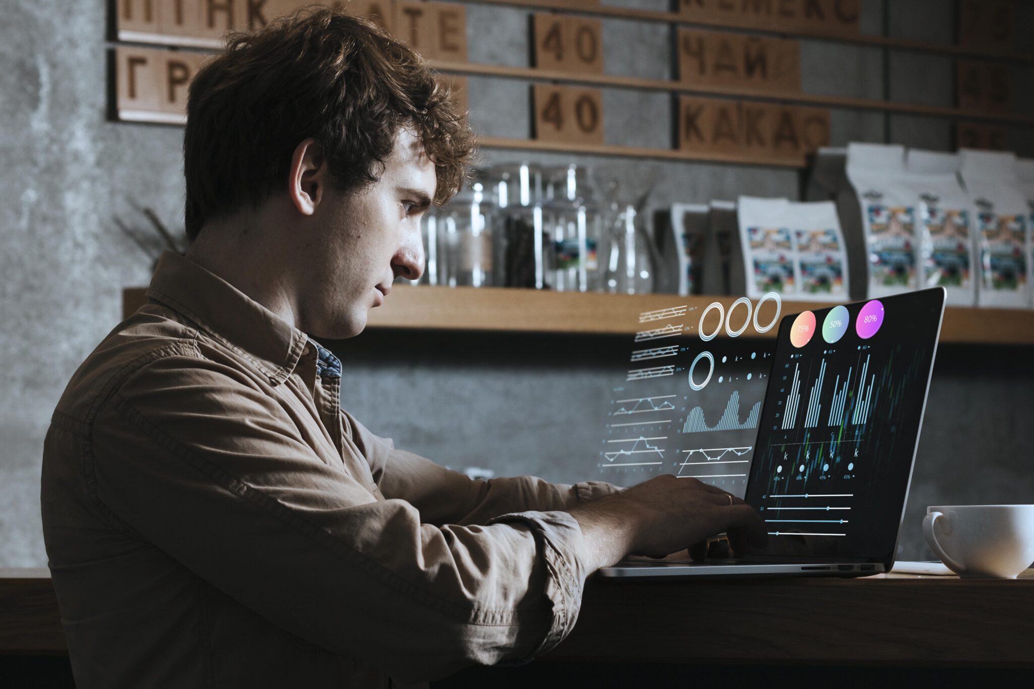 Mann analysiert digitale Datenvisualisierung in modernem Café, Thema: Analysetrends und Innovationen in der Datentechnologie.